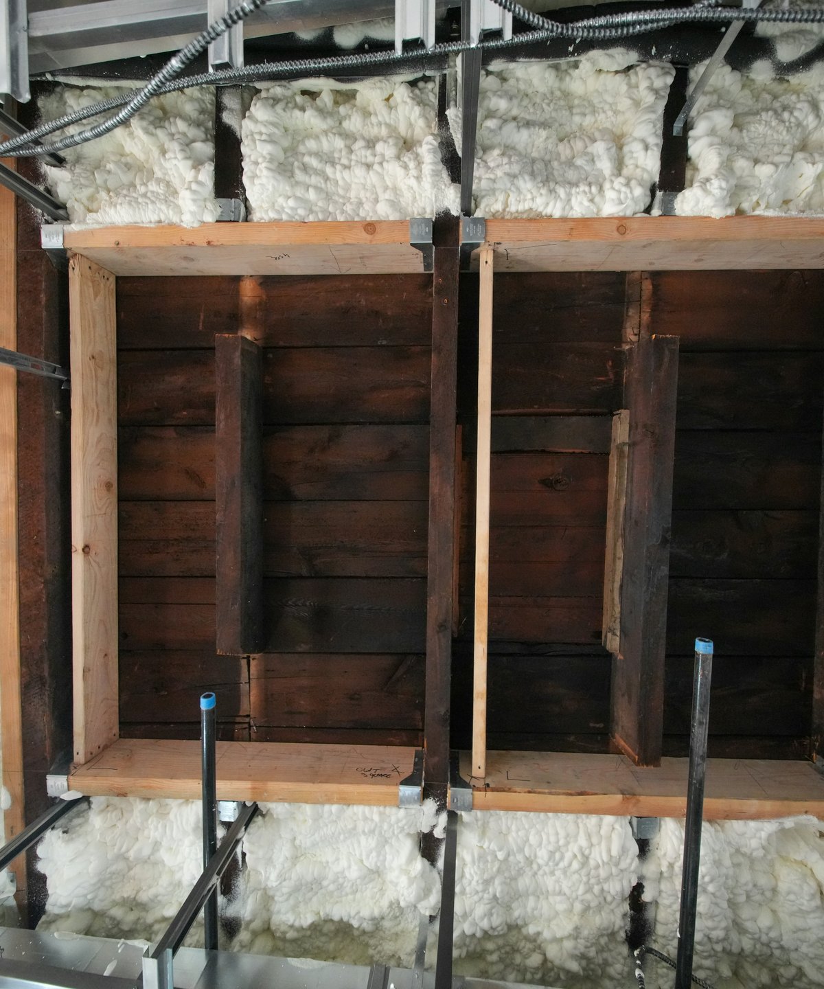 Closed-cell spray polyurethane foam filling the cavities around timber framing